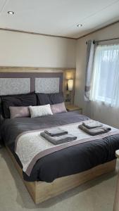a bedroom with a large bed with towels on it at Immaculate 3-Bed Lodge in Out Rawcliffe in Great Eccleston