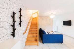 a living room with a blue couch and a staircase at Disney à 10 min: Maison paisible 8P, Wifi, Parking in Chessy