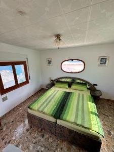 1 dormitorio con 1 cama verde en una habitación en Private Ferienwohnung mit direktem Blick aufs Meer, en Águilas