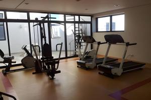 een fitnessruimte met loopbanden en crosstrainers in een kamer met ramen bij Get a Flat 909 - Conforto Ibirapuera in Sao Paulo