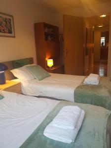 twee bedden in een hotelkamer met handdoeken erop bij Apartment on ground floor in Oxford city centre in Oxford