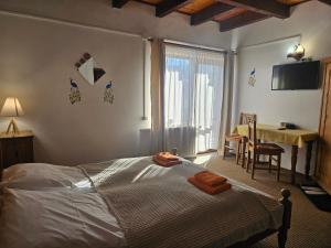 a bedroom with a bed and a table and a desk at Pensiunea Casa Gobbel in Bran