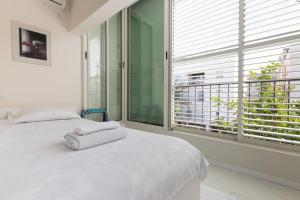 a bedroom with a white bed and a large window at Cozy 2BR Heart in Tel Aviv in Tel Aviv