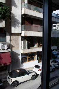 um carro branco estacionado em frente a um edifício em Cozy apartment in the best part of Pagkrati em Atenas