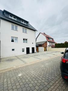 a car parked next to a white building at Sollstedt Ferienwohnung in Sollstedt