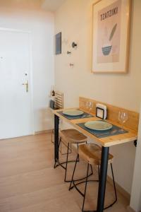 a table with two chairs and a table with glasses at Cozy apartment in the best part of Pagkrati in Athens