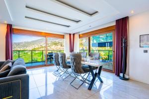 una sala da pranzo con tavolo, sedie e finestre di Alanya Luxury Villas a Alanya