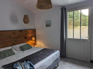 1 dormitorio con cama y ventana grande en L'Ile sous le Vent en Sainte-Marie-de-Ré