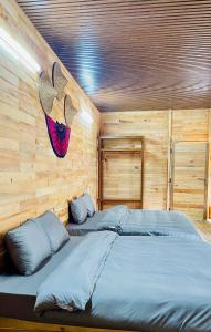 1 dormitorio con 2 camas en una habitación con paredes de madera en Chiba Lodge Mù Cang Chải en Mù Cang Chải