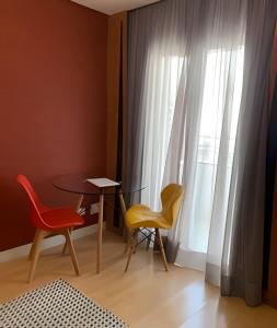 Habitación con 2 sillas, mesa y ventana en Get a Flat 701 - Ibirapuera -Jardins, en São Paulo