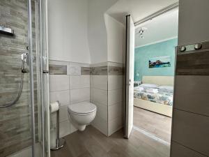 a bathroom with a toilet and a bed at Fezzano / Portovenere Stilish double rooms with sea view, balcony or small courtyard in Fezzano