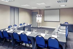 a conference room with a long table and blue chairs at Get a Flat 701 - Ibirapuera -Jardins in Sao Paulo