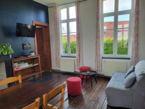 a living room with a couch and a table at Le Presbytère de la côte d'opale in Nempont-Saint-Firmin