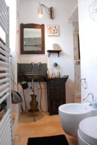 uma casa de banho com um lavatório e um espelho em Conibianchi Lamia&YurtArt House em Ceglie Messapica
