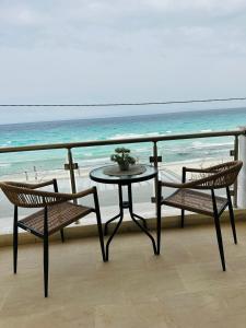a table and two chairs on a balcony with the ocean at Afrodite Seaside Rooms in Kallithea Halkidikis