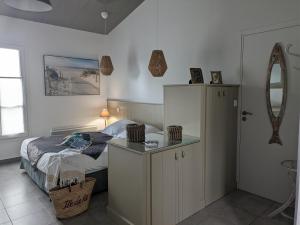 um quarto com uma cama, um armário e um espelho em L'Ile sous le Vent em Sainte-Marie-de-Ré