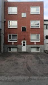 ein leerer Parkplatz vor einem Backsteingebäude in der Unterkunft Scandinavian Studio with Full Kitchen and Bath by Den Stays in Montreal