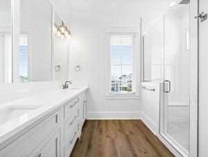 Un baño blanco con lavabo y ducha. en Ta-Kee-La Sunset at The Osprey, en Orange Beach 12 fotos más