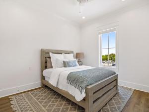Un dormitorio blanco con una cama grande y una ventana. en Ta-Kee-La Sunset at The Osprey, en Orange Beach