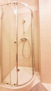 a shower with a glass door in a bathroom at HomeComfort Apartament Gulia in Warsaw +11 photos