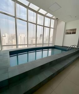 een zwembad in een gebouw met een groot raam bij Get a Flat 601 Ibirapuera -Jardins in Sao Paulo