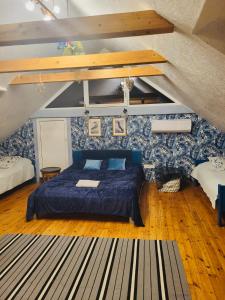 a bedroom with a blue bed in a attic at Residence R&R in Karvys