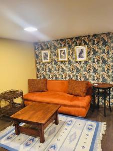 a living room with an orange couch and a table at Residence R&R in Karvys
