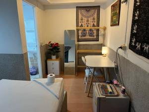 een kleine kamer met een bed, een tafel en een bureau bij Sunset Serenity Cove in Ko Pha Ngan