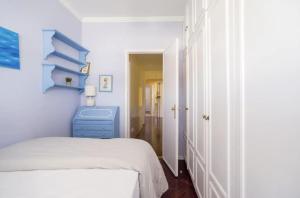 a white bedroom with a bed and a blue dresser at Spacious Apartment in Belém in Lisbon