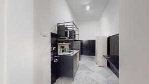 a kitchen with white walls and a black refrigerator at Ai Crociferi in Palermo