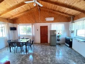 a kitchen and dining room with a table and chairs at Cabaña con jacuzzi, 7 personas. in Quillón