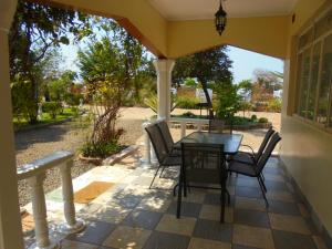 a patio with a table and chairs on a porch at White Rose Lodge in Livingstone