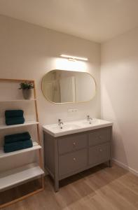 een badkamer met een wastafel en een spiegel bij Ten Velde in Hoeselt
