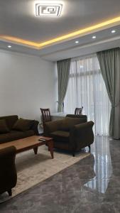 a living room with two couches and a coffee table at Onset Apartment in Addis Ababa