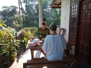 een man en een vrouw aan een tafel op een veranda bij Sadula Homestay Ella in Ella