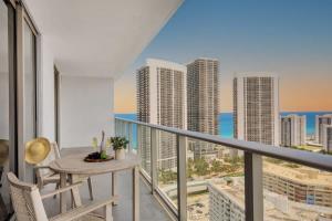 einen Balkon mit einem Tisch und Stühlen sowie Stadtblick in der Unterkunft Luxury 3 Br- Front Intercostal View - Amazing Pools in Hollywood