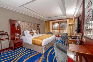 a hotel room with a bed and some chairs at Dar Al Taqwa Hotel in Al Madinah