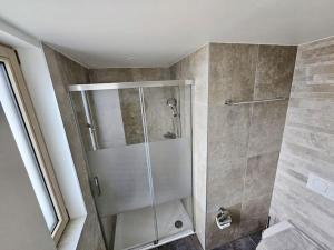eine Dusche mit Glastür im Bad in der Unterkunft Walking steps from Lake Geneva in Lutry