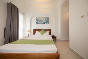 - une chambre avec un lit vert et blanc et une fenêtre dans l'établissement Ngọc Châu Hotel, à Hô-Chi-Minh-Ville