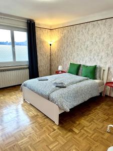 a bedroom with a large bed with green pillows at Maison entière/ Entire house with privat 3 Parking in Kayl