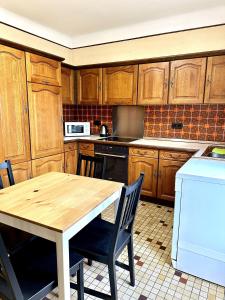 a kitchen with wooden cabinets and a wooden table at Maison entière/ Entire house with privat 3 Parking in Kayl