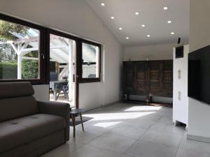 a living room with a couch and a tv at Ferienhaus Schönach in Herdwangen-Schönach