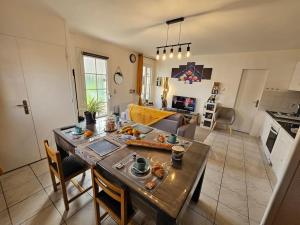 uma cozinha e sala de estar com uma mesa com comida em Ô P'tit Billard Baventais em Bavent