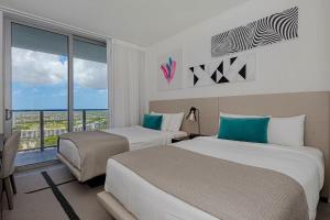 ein Hotelzimmer mit zwei Betten und einem Fenster in der Unterkunft Luxury with stunning view, Balcony, Amazing Pools in Hollywood