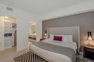 ein Schlafzimmer mit einem großen Bett mit einem rosa Kissen in der Unterkunft Luxury with stunning view, Balcony, Amazing Pools in Hollywood