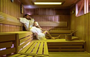 a man and woman sitting in a sauna at Wellness- und Familienhotel Egger in Saalbach-Hinterglemm