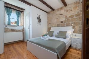 um quarto com uma cama e uma parede de tijolos em Manero em Trogir