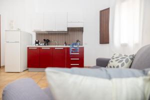 eine Küche mit roten Schränken und einem Waschbecken im Zimmer in der Unterkunft Ni Ni Apartments - Self Check in in Cefalú