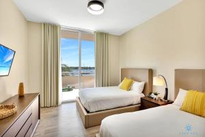 a hotel room with two beds and a large window at Beachfront Condo-ROOFTO POOL- 2 BEDROOMS 2 BR ! in Hollywood