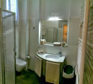 ein Badezimmer mit einem Waschbecken, einem WC und einem Spiegel in der Unterkunft Casa Chiara suite Sole in Parma